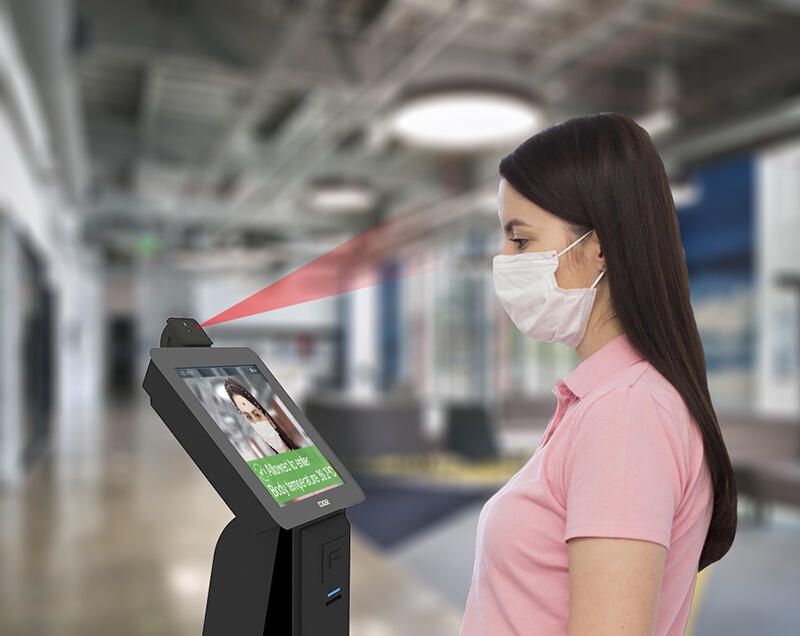 Woman standing in front of auto fever detector device from SEDCO Woman standing in front of auto fever detector device from SEDCO